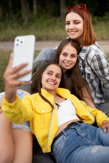 Zdjęcie przyjaciele ze średnim ujęciem robiący selfie