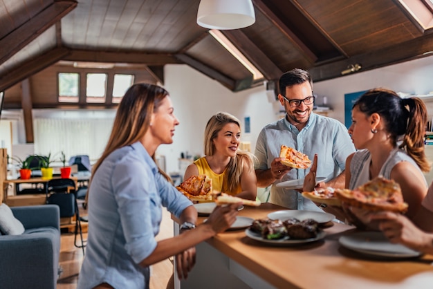 Przyjazny zespół biznes jedzenie pizzy razem w biurze coworking.