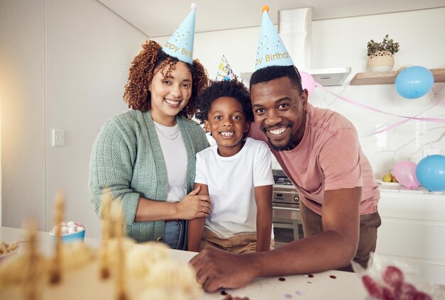 Przyjęcie urodzinowe i portret rodziny w kuchni na celebrację, wiązanie i czułość Szczęście podekscytowane i opieka z rodzicami i dzieckiem w domu na niespodziankę i specjalne wydarzenie