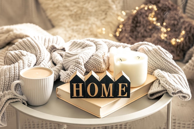 Zdjęcie przyjemna kompozycja ze świecami, kawą i dekoracyjnym słowem do domu.