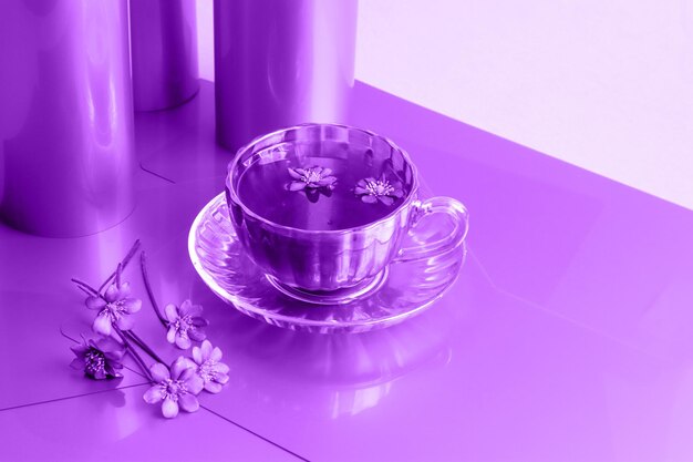 Przyjemne picie herbaty w wiosenny dzień filiżankę herbaty obok bukietu wiosennych kwiatów na pastelowym tle w odcieniach fioletu widok z boku miejsca na tekst