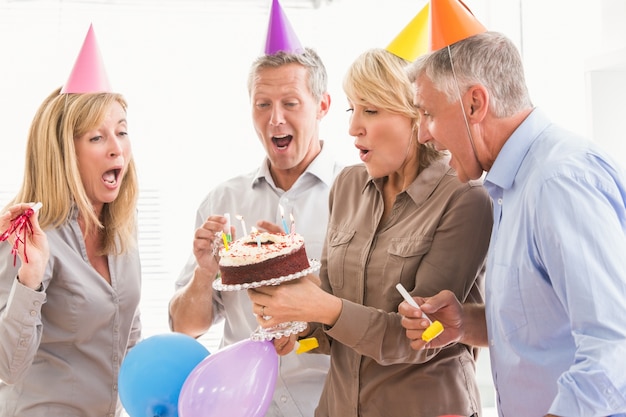 Przypadkowi ludzie biznesu dmucha urodzinowe świeczki