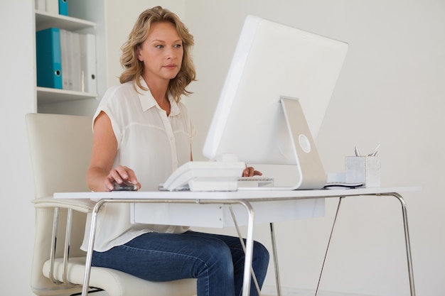 Zdjęcie przypadkowy bizneswoman pracuje przy jej biurkiem