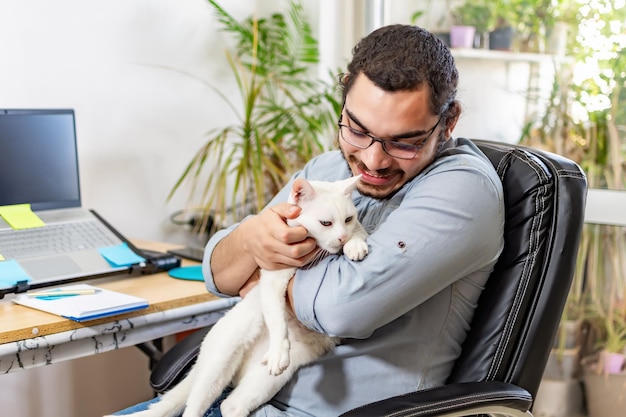 Przypadkowy freelancer robi sobie przerwę od pracy zdalnej z kotem