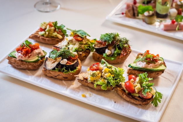 Przystawki na weselu wykwintna bruschetta z pasztetem z cukinii, pomidorem, ogórkiem i ziołami