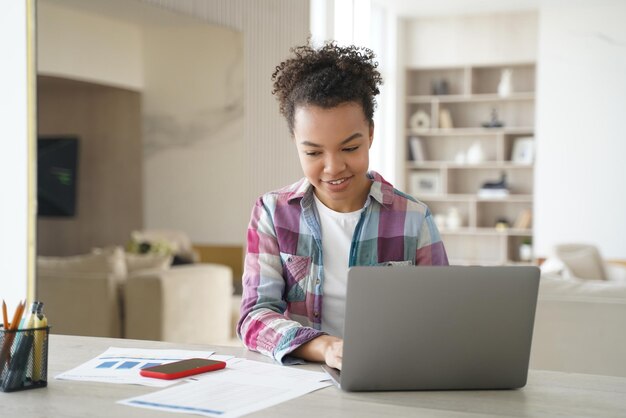 Przystojna dziewczyna afro uczy się zdalnie na kwarantannie Szczęśliwa nastolatka ma sesję lekcji internetowych