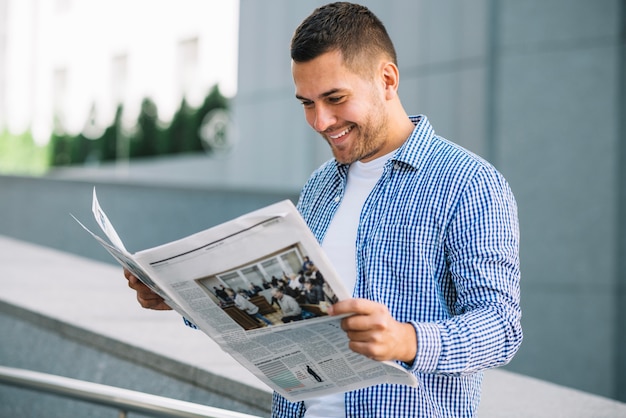 Zdjęcie przystojnego mężczyzna czytelnicza gazeta na ulicie