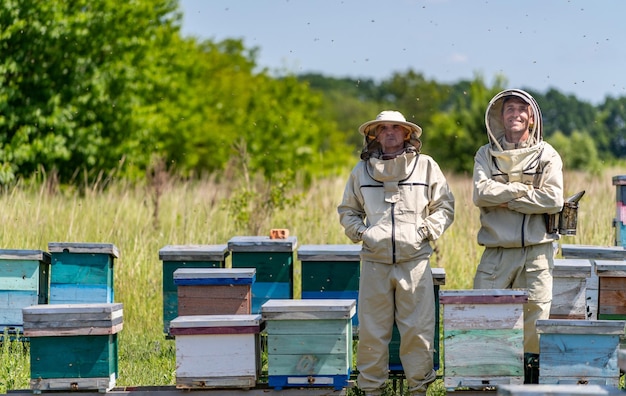 Przystojni specjaliści pszczelarstwa Pracownicy hodowli miodu w pasiece