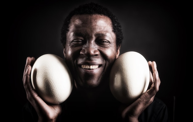 Przystojny afrykański czarny mężczyzna ze strusim jajkiem
