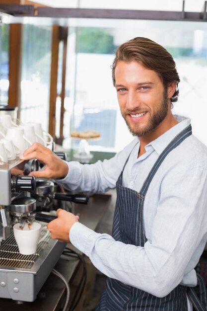 Przystojny barista robi filiżance kawy