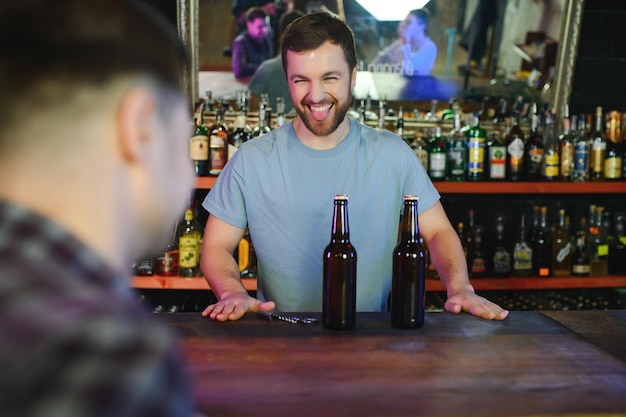 Przystojny barman stojący za ladą w pubie