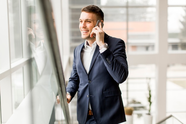 Przystojny biznesmen w klasycznym garniturze rozmawia przez telefon komórkowy