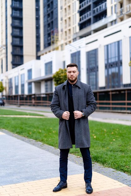 Przystojny biznesmen w stylowej ulicy miasta. Styl życia pewnie elegancki mężczyzna stojący na nowoczesnej ulicy.