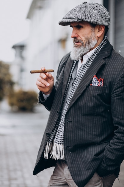 Przystojny brodaty mężczyzna palący papierosa
