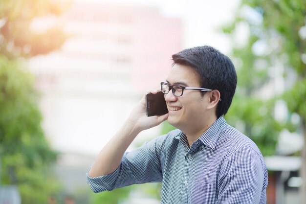 Przystojny Człowiek Biznesu W Korzystaniu Z Inteligentnego Telefonu Komórkowego Cieszę. Azjatycki Mężczyzna