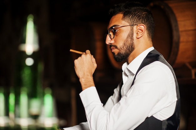 Przystojny Dobrze Ubrany Mężczyzna Arabski Ze Szklanką Whisky I Cygarem Postawiony W Pubie.