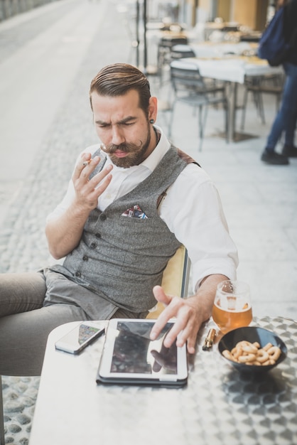 przystojny duży wąsy hipster człowiek za pomocą tabletu