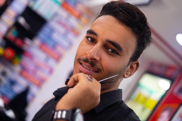 Przystojny fryzjer arabski mężczyzna portret z nożyczkami