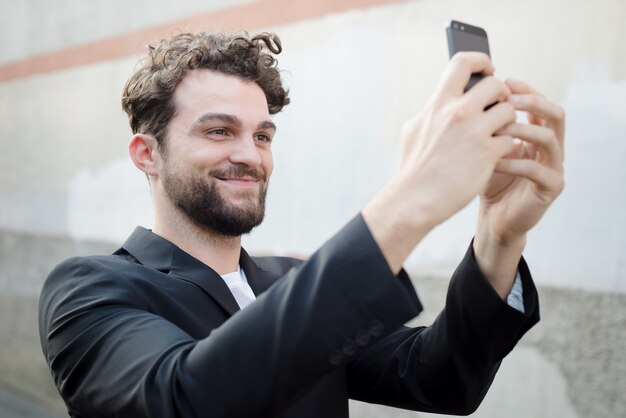 przystojny hipster nowoczesny człowiek za pomocą inteligentnego telefonu selfie