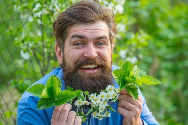 Przystojny hipster uśmiechający się do kamery w dzień lata lub wiosny z bliska portret szczęśliwego człowieka wiosny