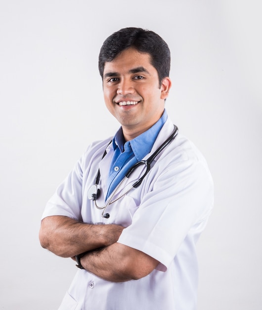 Przystojny indyjski mężczyzna lekarz z wesołymi wyrazami twarzy i złożonymi rękami. stojąc na białym tle na białym tle
