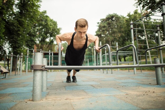 Przystojny Kaukaski Sportowiec Robi ćwiczenia Push Up Na Poręczach W Siłowni Na świeżym Powietrzu