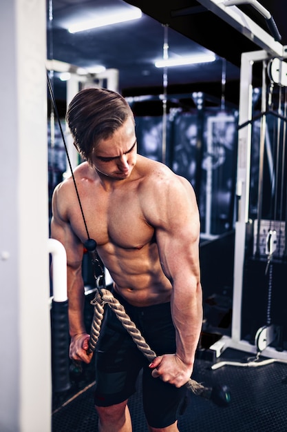 Przystojny kulturysta fitness mięśni robi ciężkie ćwiczenia na triceps