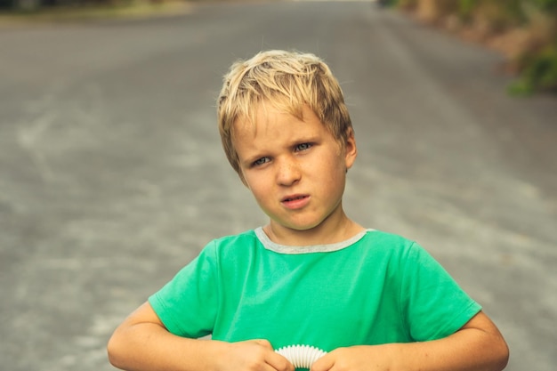 Przystojny ładny blond chłopiec zielony tshirt w złym nastroju myślę Artystyczne emocje i gestykulując Problem lub szczęśliwe dzieciństwo zachowanie edukacja psychologia rodzina relacja przyjaźń ludzie koncepcja