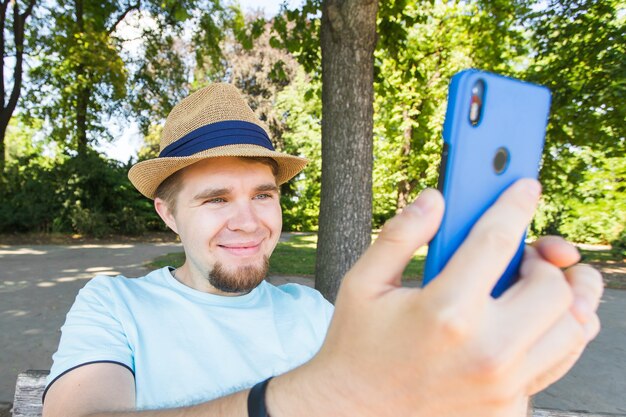 Przystojny mężczyzna bierze selfie odkryty - kaukaski ludzie - natura, ludzie, styl życia i koncepcja technologii.