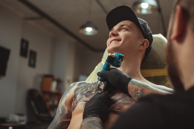 Przystojny mężczyzna dostaje tatuaż w alternatywnym studiu sztuki