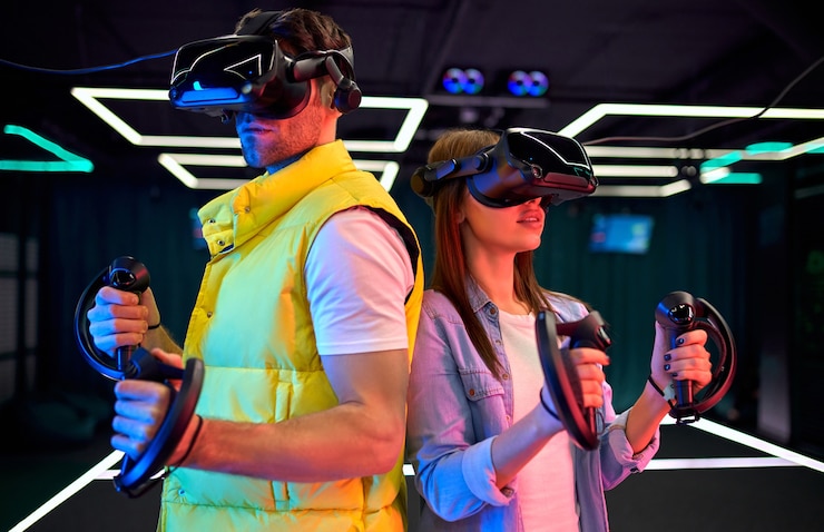 Zdjęcie przystojny mężczyzna i piękna młoda kobieta w okularach wirtualnej rzeczywistości. vr, gry, rozrywka, koncepcja technologii przyszłości. para z zestawem słuchawkowym do wirtualnej rzeczywistości, wspólna zabawa.