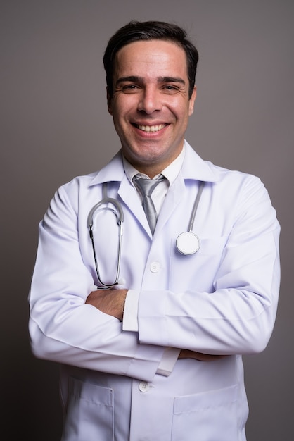 Przystojny mężczyzna perski lekarz przed szarej ścianie