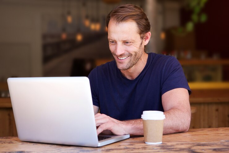 Przystojny mężczyzna pracuje na laptopie