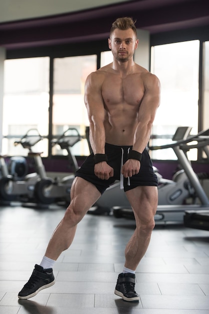 Przystojny Mężczyzna Stojący Silny W Nowoczesnej Siłowni I Napinający Mięśnie Mięśni Atletyczny Kulturysta Model Fitness Pozujący Po Ćwiczeniach