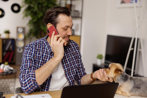 Przystojny mężczyzna w kraciastej koszuli rozmawia przez telefon komórkowy z przyjacielem