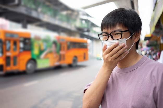 Przystojny mężczyzna w masce chroni filtr przed zanieczyszczeniem powietrza (PM2,5)