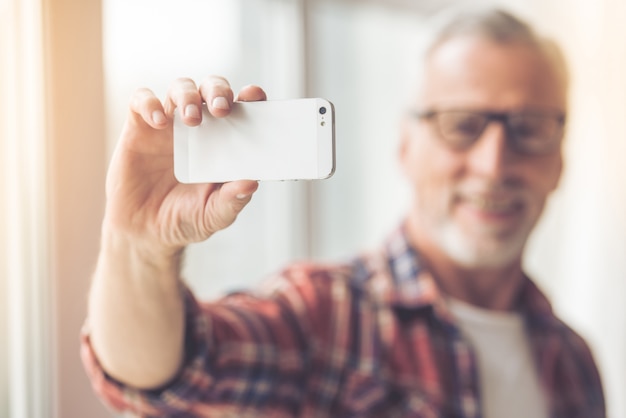 Przystojny mężczyzna w okularach robi selfie