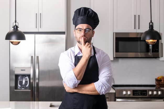 Przystojny mężczyzna w średnim wieku w mundurze szefa kuchni, gotowanie w kuchni i koncepcja menu restauracji kulinarnej