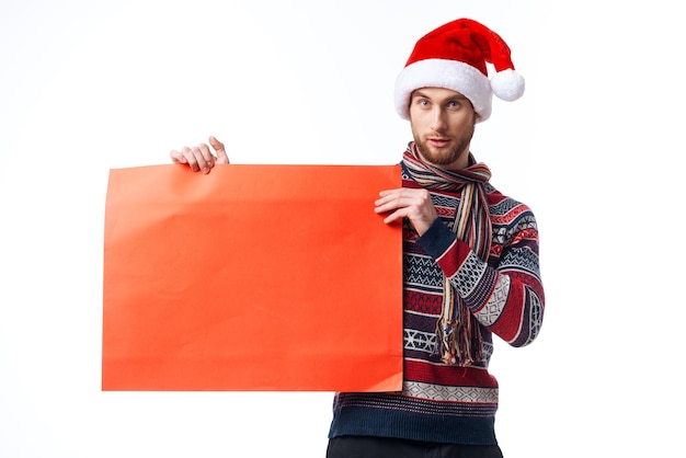 Przystojny mężczyzna w ubraniach noworocznych trzymając transparent wakacje jasne tło