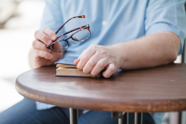 Przystojny młody biznesmen czyta książkę w przypadkowych ubraniach i eyeglasses