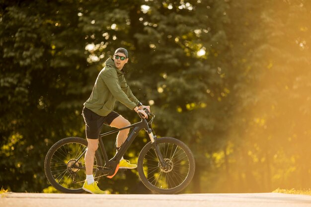 Przystojny młody mężczyzna jedzie na ebike w przyrodzie