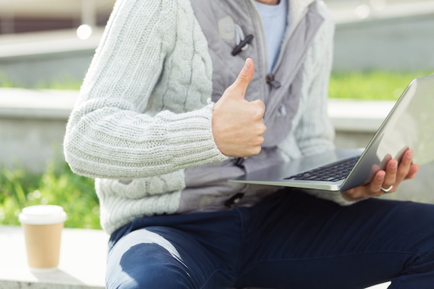 Przystojny Młody Mężczyzna Pracujący Na Laptopie I Uśmiechający Się Na Ulicy Miasta