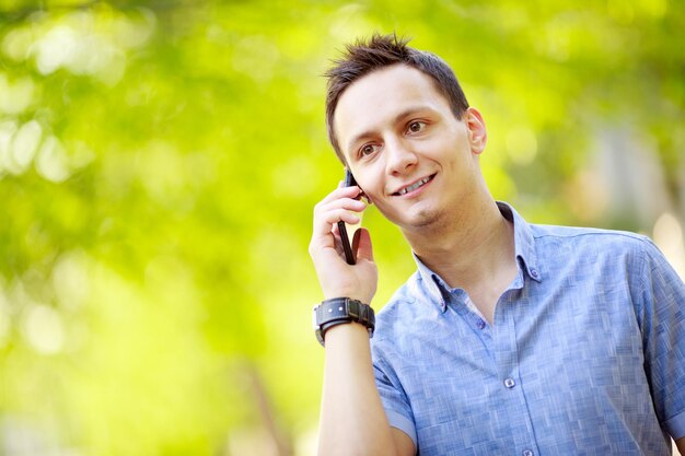 Przystojny młody mężczyzna rozmawia przez telefon komórkowy