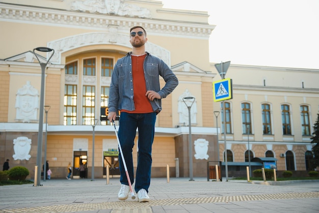 Zdjęcie przystojny niewidomy spaceruje po mieście