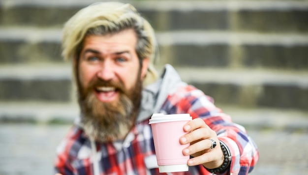 Przystojny spokojny brodaty mężczyzna na zewnątrz z kubkiem Mężczyzna pijący gorącą kawę turysta relaks na schodach pić kawę lub herbatę Kawa w podróży