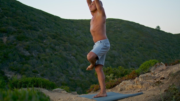 Przystojny sportowiec robi rozciąganie jogi na matę przydatności Pociąg mięśni łysy mężczyzna
