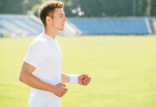 Przystojny sportowy mężczyzna biega outdoors przy wschodem słońca.