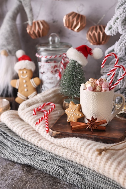Przytulna świąteczna kompozycja z filiżanką i ciasteczkami. Gorąca czekolada z pianką marshmallow.