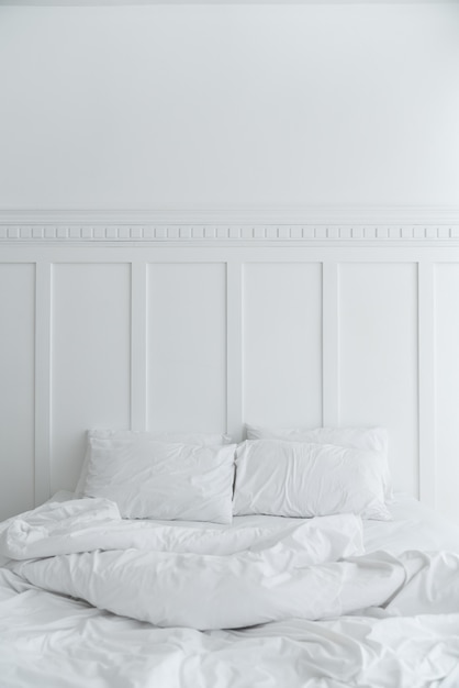 Zdjęcie przytulna sypialnia z dwiema poduszkami i brudnym kocem na białej ścianie