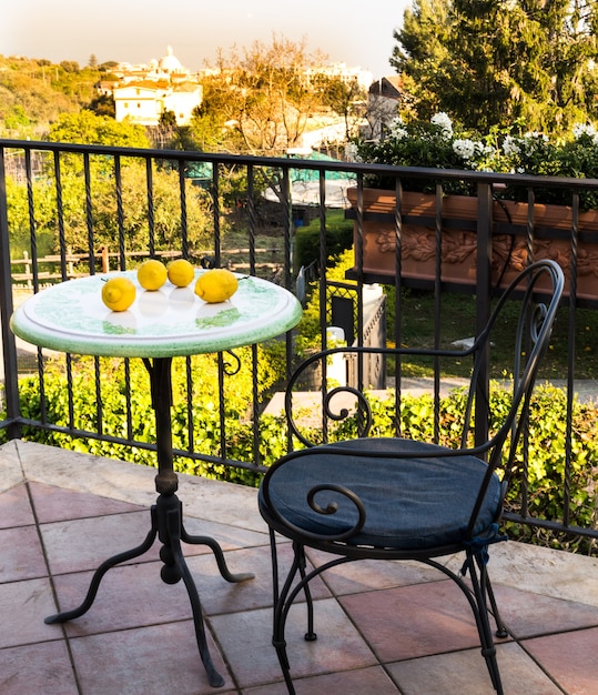 Przytulne kute meble na balkonie lub tarasie z widokiem na ogród. Miejsce na odpoczynek